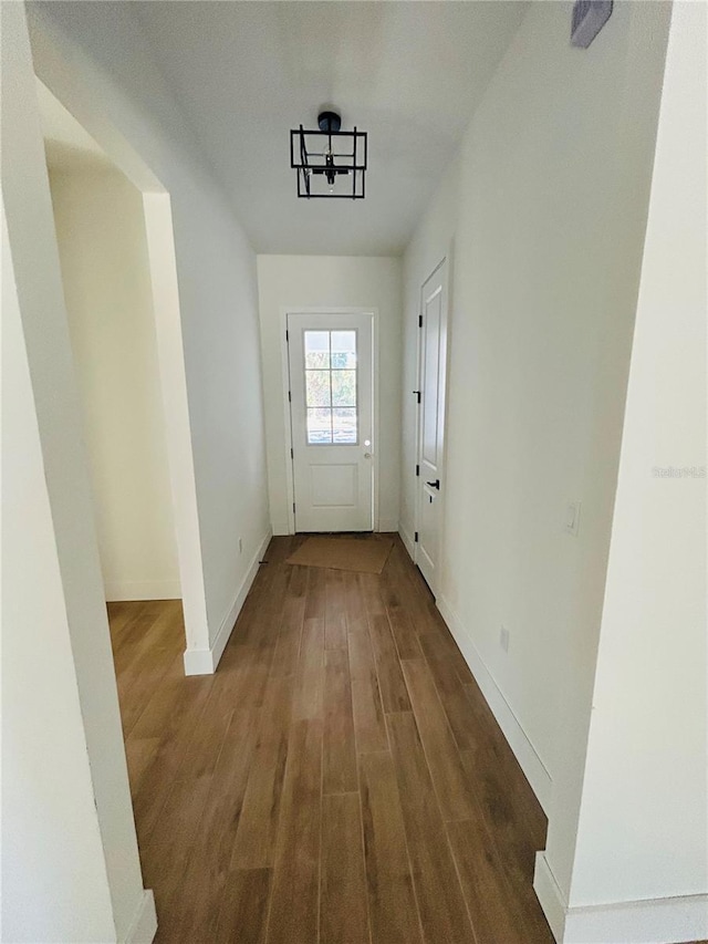 doorway to outside featuring a chandelier and dark hardwood / wood-style floors