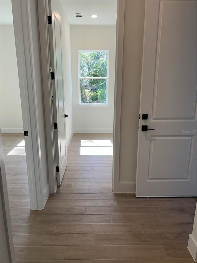 hallway with light hardwood / wood-style flooring