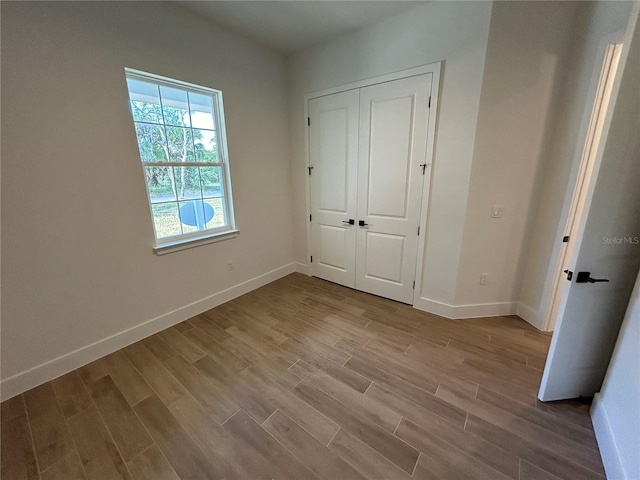 unfurnished bedroom featuring light wood-type flooring and a closet