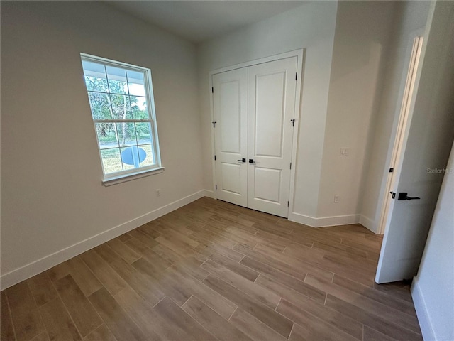 unfurnished bedroom featuring light hardwood / wood-style floors and a closet