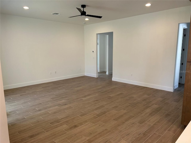 spare room with dark wood-type flooring and ceiling fan