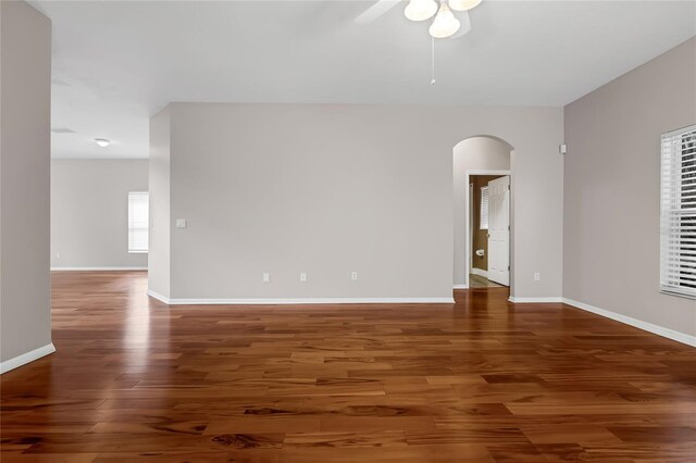 empty room with dark wood-type flooring and ceiling fan