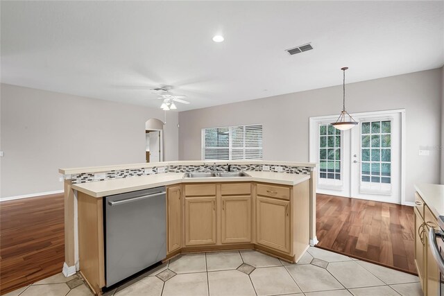 kitchen with ceiling fan, backsplash, stainless steel dishwasher, light wood-type flooring, and sink