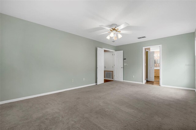 unfurnished bedroom with connected bathroom, light colored carpet, and ceiling fan