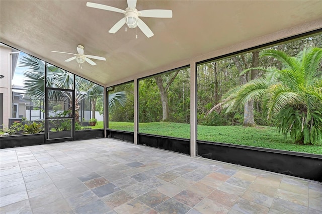 unfurnished sunroom featuring ceiling fan, plenty of natural light, and vaulted ceiling