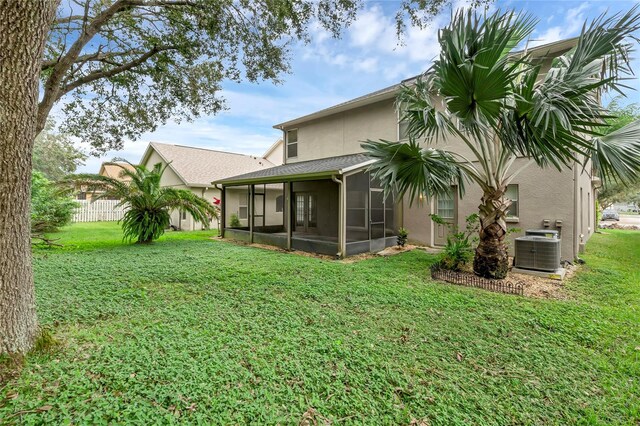 back of property featuring cooling unit, a lawn, and a sunroom