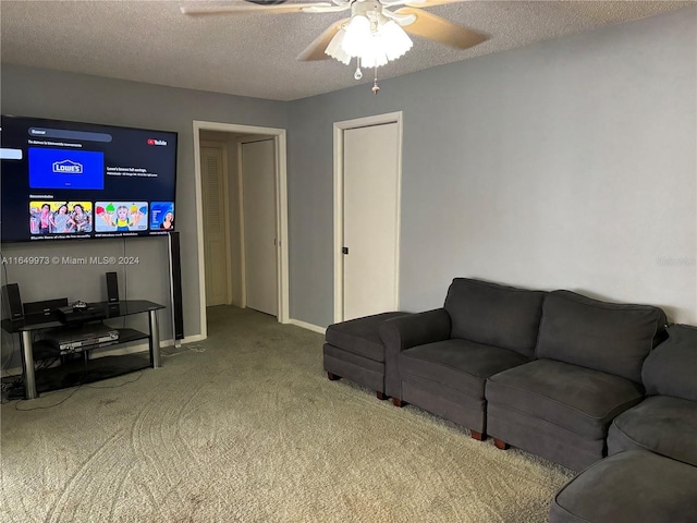 carpeted living room featuring ceiling fan and a textured ceiling