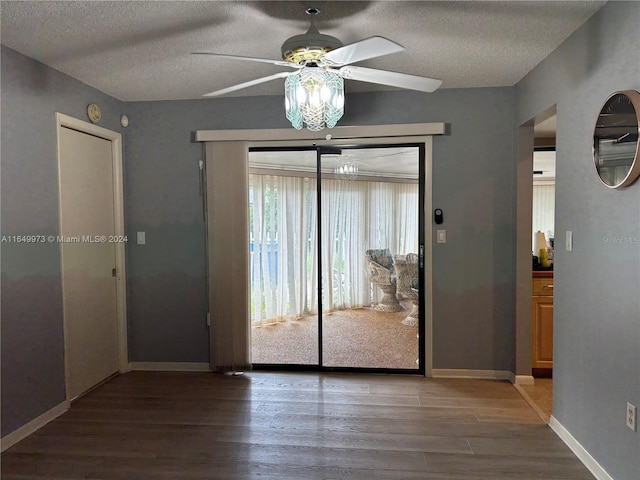 interior space with ceiling fan, a textured ceiling, and wood-type flooring