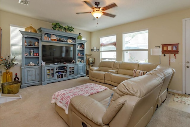 living area with ceiling fan, visible vents, and light colored carpet