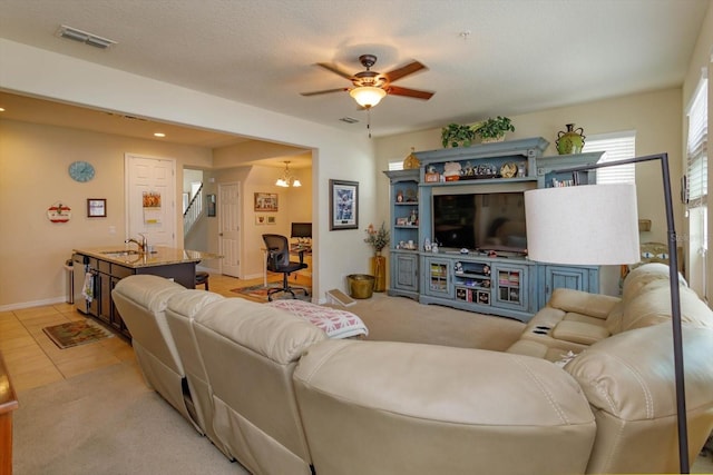 living room featuring stairway, light tile patterned floors, ceiling fan with notable chandelier, a textured ceiling, and visible vents