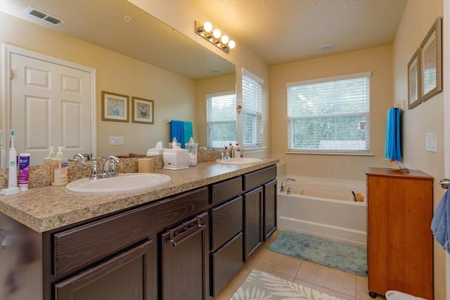 bathroom with a sink, visible vents, tile patterned floors, and a bath