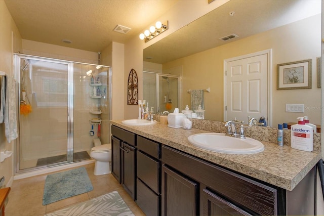 bathroom with tile patterned flooring, vanity, toilet, and an enclosed shower