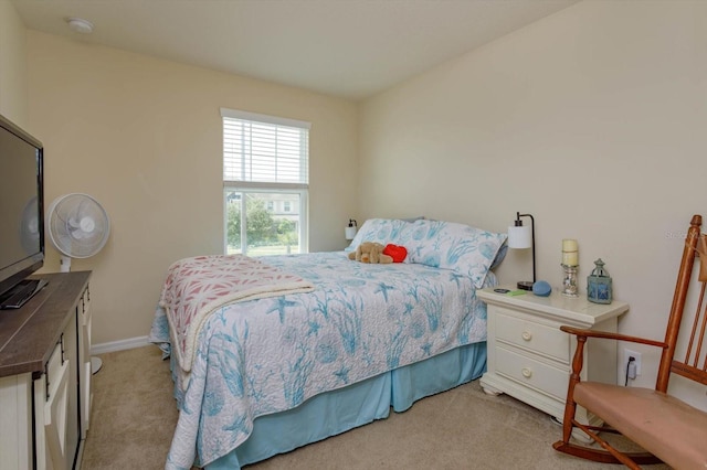bedroom with baseboards and light colored carpet