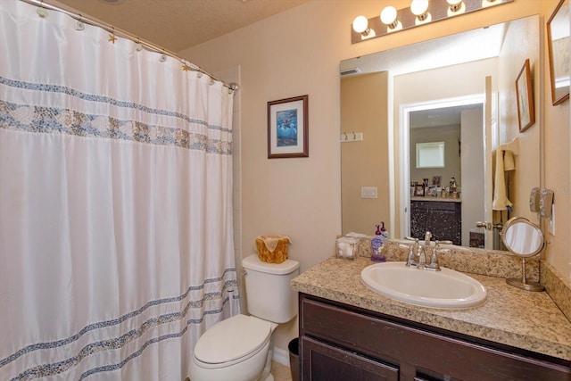 bathroom featuring a textured ceiling, curtained shower, vanity, and toilet