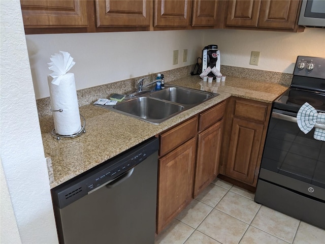 kitchen with light tile patterned flooring, appliances with stainless steel finishes, and sink