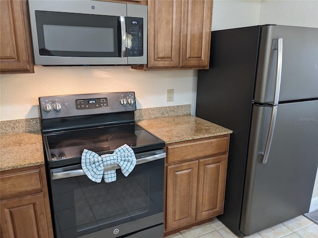 12527 Floridays Resort Dr Unit 510E, Orlando, FL 32821 - kitchen with light stone countertops, light tile patterned flooring, and appliances with stainless steel finishes