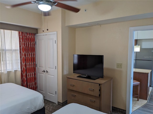 12527 Floridays Resort Dr Unit 510E, Orlando, FL 32821 - bedroom featuring ceiling fan, a closet, stainless steel fridge, and wood-type flooring