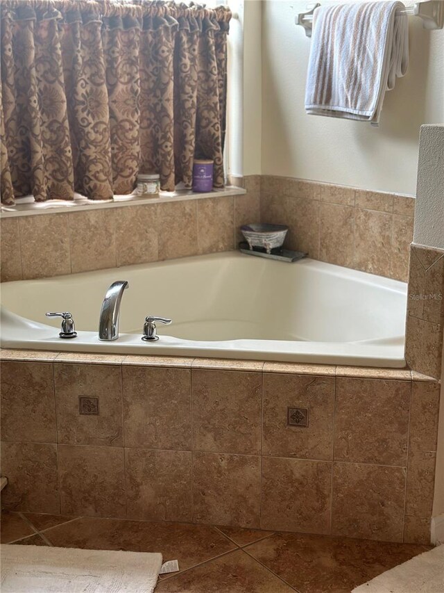 bathroom with tiled bath and tile patterned floors