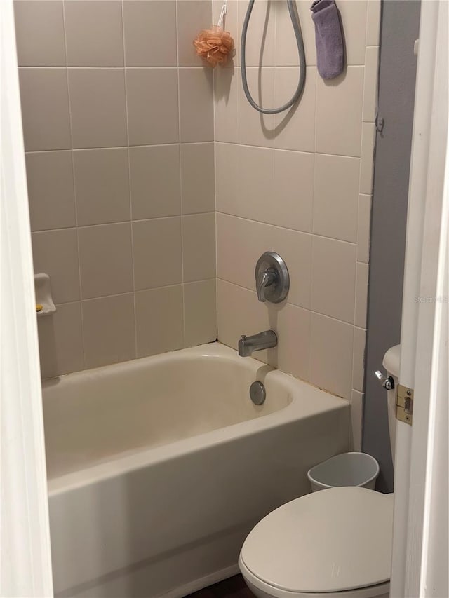 bathroom with tiled shower / bath and toilet