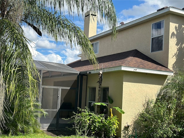 rear view of property featuring glass enclosure