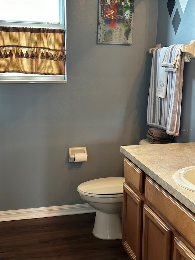 bathroom with wood-type flooring, vanity, and toilet