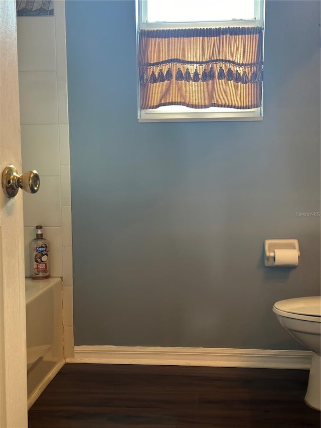 bathroom with wood-type flooring, toilet, and a healthy amount of sunlight