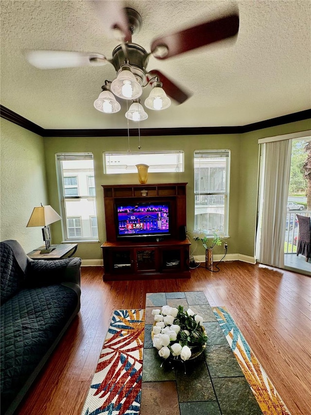 living room featuring ceiling fan, wood-type flooring, and a wealth of natural light