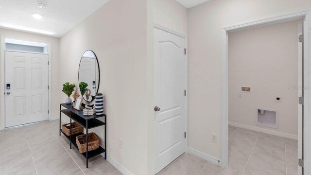 entryway featuring light tile patterned flooring and baseboards