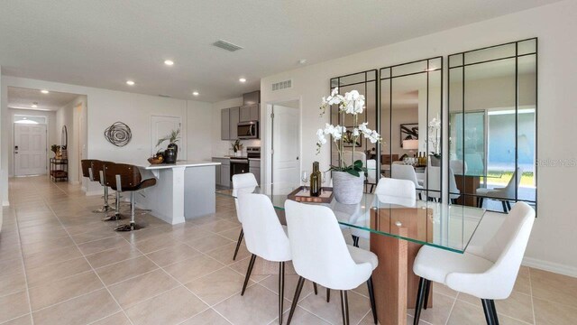 dining area featuring light tile patterned flooring, baseboards, visible vents, and recessed lighting