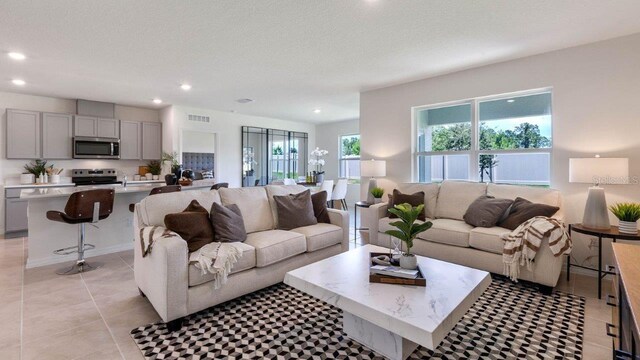 living room featuring a textured ceiling, visible vents, and recessed lighting