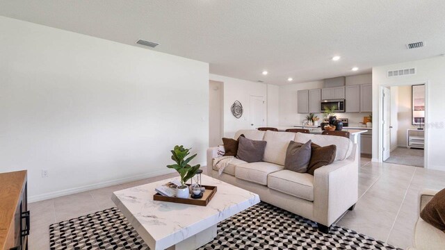 living room featuring recessed lighting, a textured ceiling, and visible vents