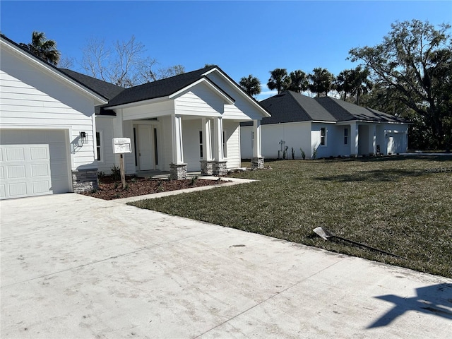 view of front of home with a garage, a front yard, and covered porch