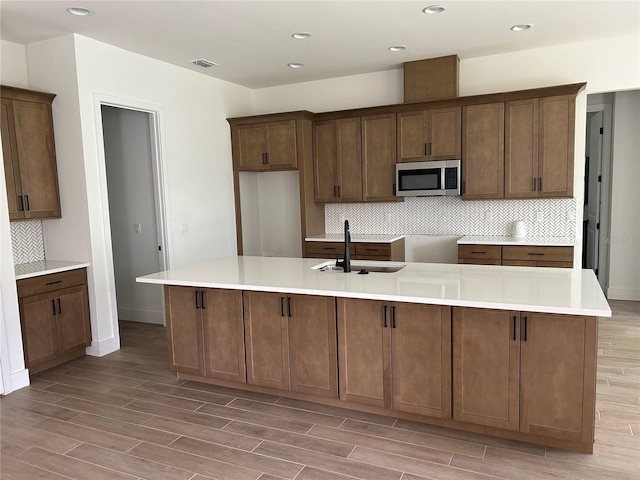 kitchen featuring tasteful backsplash, a large island, and sink