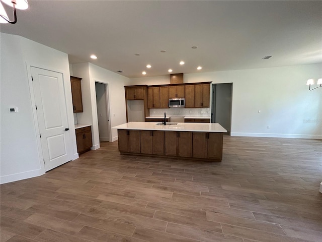 kitchen featuring sink, hardwood / wood-style floors, and a kitchen island with sink