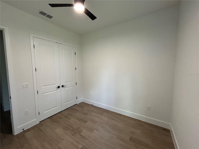 unfurnished bedroom with hardwood / wood-style floors, ceiling fan, and a closet