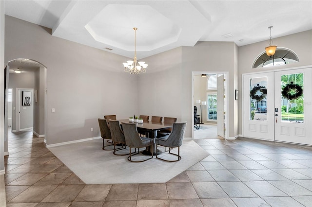 dining area featuring french doors, light tile patterned flooring, and a notable chandelier