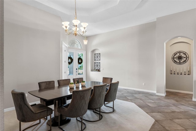 dining space featuring a notable chandelier, french doors, and a tray ceiling