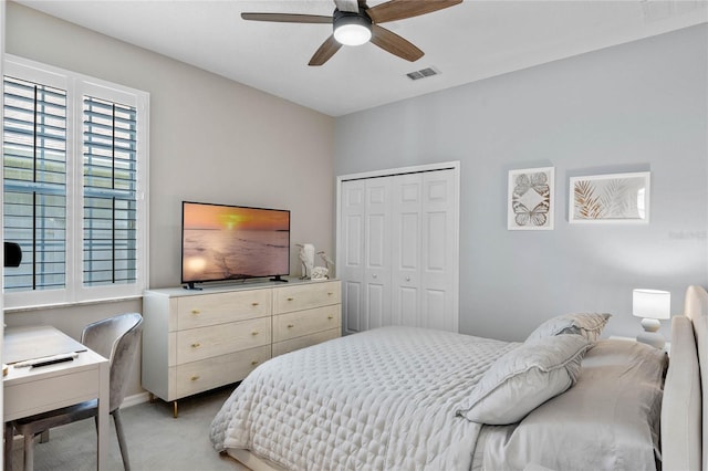 bedroom featuring ceiling fan, a closet, and light colored carpet