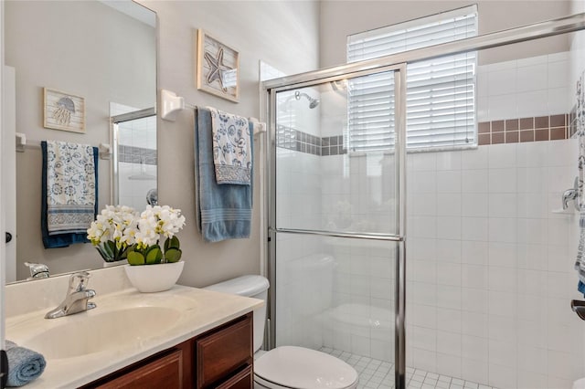 bathroom with an enclosed shower, vanity, and toilet