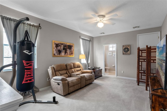 living room featuring ceiling fan, carpet floors, and a textured ceiling