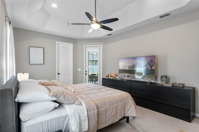 bedroom with access to exterior, light colored carpet, a raised ceiling, and ceiling fan