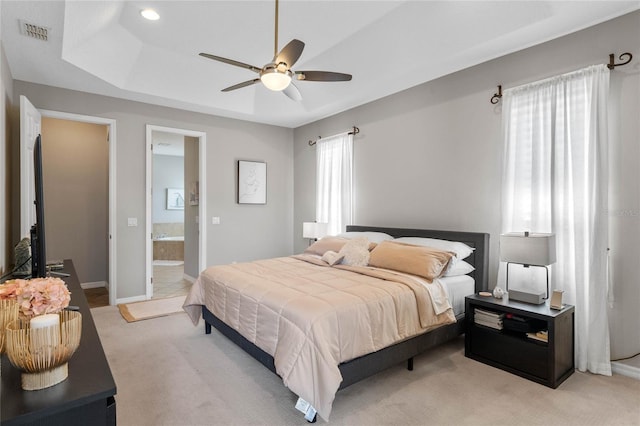 bedroom with ensuite bathroom, ceiling fan, and light colored carpet