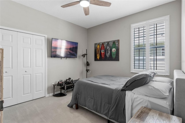 bedroom featuring a closet, ceiling fan, and light colored carpet