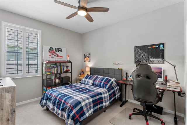 bedroom with a textured ceiling, light colored carpet, and ceiling fan