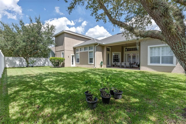 back of house featuring a lawn and a patio