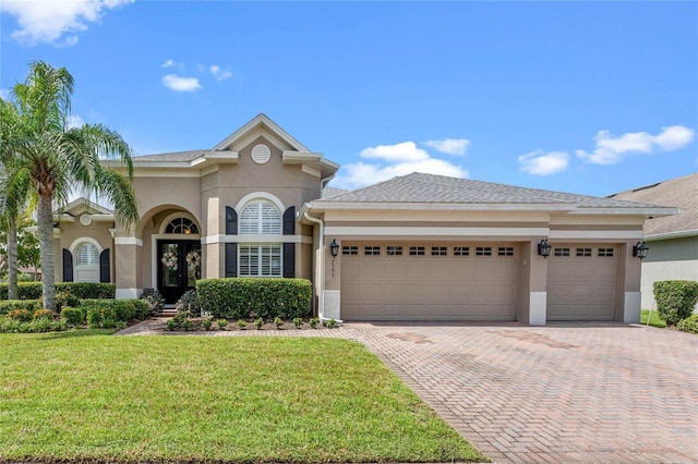 view of front of house with french doors, a garage, and a front lawn