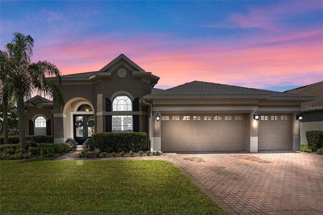 view of front of house with a yard and a garage