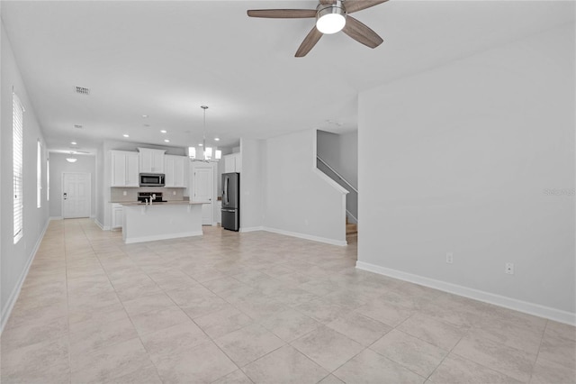 unfurnished living room with light tile patterned flooring and ceiling fan with notable chandelier