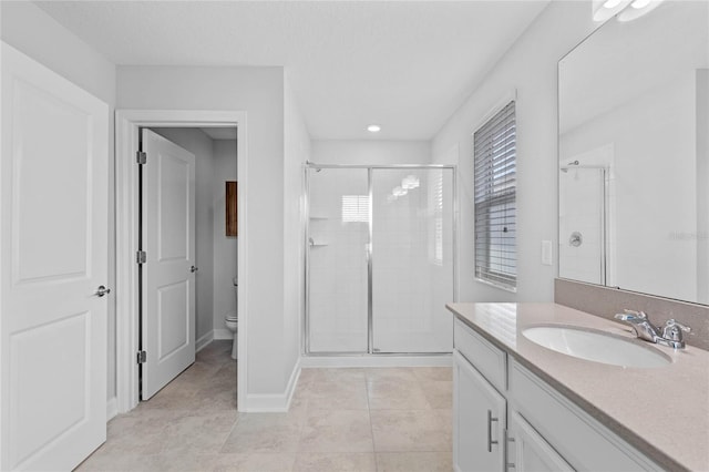 bathroom featuring tile patterned flooring, vanity, toilet, and a shower with door