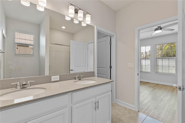 bathroom with walk in shower, vanity, hardwood / wood-style floors, and ceiling fan